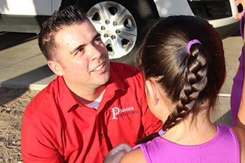 Marc Gonzales Owner of PremierX Pest speaking with little girl.